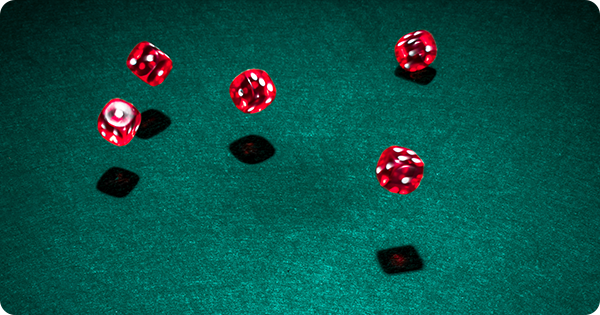 Cinco dados vermelhos sobre uma mesa verde, simbolizando o elemento de aleatoriedade nos jogos/